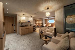 a living room with a couch and chairs and a kitchen at Residence Angelika in Corvara in Badia