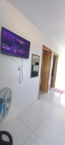 a flat screen tv on the wall of a room at Pousada Germânia em Paraíso do Sul RS in Paraíso do Sul