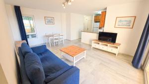 a living room with a blue couch and a table at Casinomar Apartments Pool, Garden & Private Terrace in Benalmádena