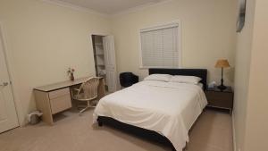a bedroom with a bed and a desk and a desk at 温哥华温西别墅民宿47 in Vancouver
