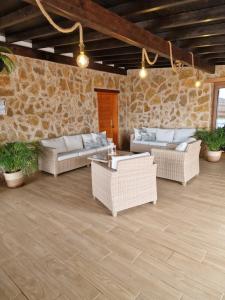 a patio with wicker furniture and a stone wall at Casa Abuela Serapia in Tuineje +41 photos