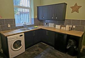 a kitchen with a washing machine and a sink at Cog Lane House in Burnley
