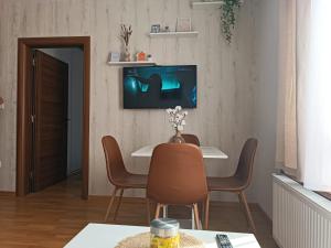 a living room with a table and chairs and a tv on the wall at Divci Nova1- A8 in Divčibare