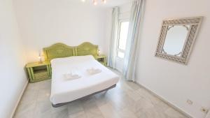 a bedroom with a white bed and a mirror at Casinomar Apartments Pool, Garden & Private Terrace in Benalmádena +50 photos