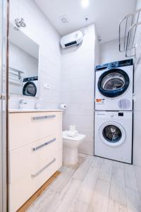 a bathroom with a washing machine and a toilet at ABC Apartments Madrid in Madrid