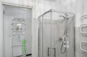 a shower with a glass door in a bathroom at Seafront, Large Studio on the Beach with AC and WiFi in Pietra Ligure +9 photos