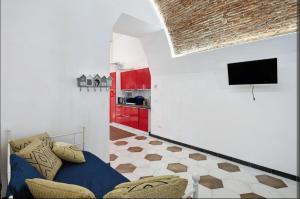 a living room with a couch and a tv at Seafront, Large Studio on the Beach with AC and WiFi in Pietra Ligure