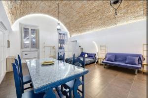 a living room with a table and blue chairs at Seafront, Large Studio on the Beach with AC and WiFi in Pietra Ligure