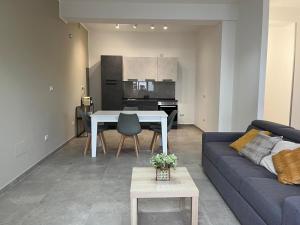 ein Wohnzimmer mit einem blauen Sofa und einem Tisch in der Unterkunft Dimora Cristella in Eboli