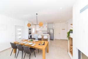 a dining room and kitchen with a wooden table and chairs at Villa Olivia Trogir in Trogir