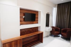 a room with a flat screen tv on a wall at Emerald Nest in Pandharpur +14 photos