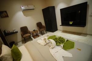 a living room with a tv and some chairs at The Leaf Farm in Ludhiana