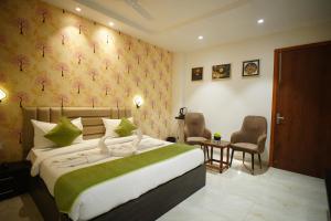 a bedroom with a bed and two chairs and a table at The Leaf Farm in Ludhiana