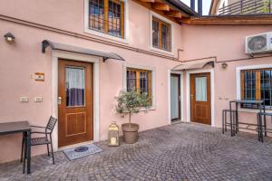 a pink house with a potted tree in a courtyard at Domus Al Concilio in Trento