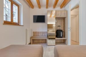 a hotel room with two beds and a tv at Domus Al Concilio in Trento
