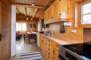 a kitchen with wooden cabinets and a sink and a table at Rundetjødn 20 in Hol