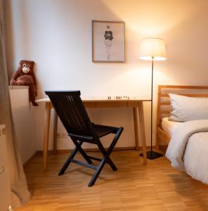 a desk with a teddy bear and a chair in a bedroom at An der Kirchtreppe in Blankenburg