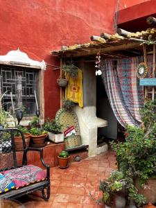 a patio with a red building with plants and a window at 34 Degrés Sud in Mirleft