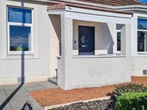 a house with a black door on the side of it at Kirklea in Wishaw