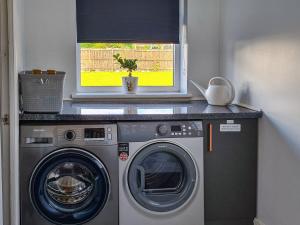 a washer and dryer in a room with a window at Kirklea in Wishaw