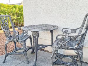 a table and two chairs next to a table and a table and chair at Kirklea in Wishaw