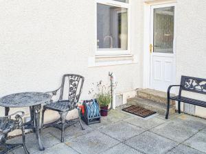 a patio with a table and chairs next to a door at Kirklea in Wishaw