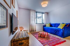 a living room with a blue couch and a table at LSA Liberdade by Numa in Lisbon