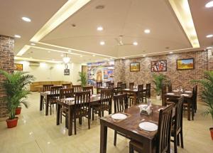 a restaurant with wooden tables and chairs and brick walls at HOTEL D'CAPITOL - DELHI AiRPORT in New Delhi
