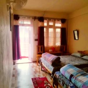 a bedroom with a bed and a couch and a window at Za Homestay in Cherrapunji
