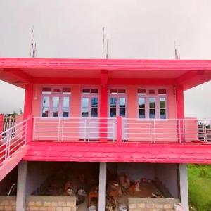 a pink building with a pink porch on top at Za Homestay in Cherrapunji