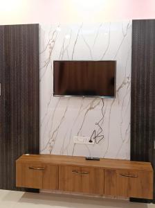 a flat screen tv on top of a wooden entertainment center at Roy Guest House in Kānki