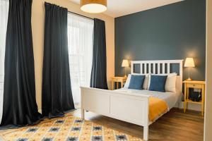 ein Schlafzimmer mit einem weißen Bett und einem großen Fenster in der Unterkunft 32 Bondgate Without in Alnwick