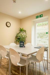 ein Esszimmer mit Tisch, Stühlen und einer Uhr in der Unterkunft 32 Bondgate Without in Alnwick + 9 Fotos