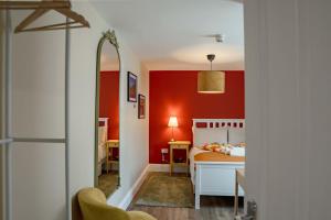 ein Schlafzimmer mit roten Wänden und einem Bett in der Unterkunft 32 Bondgate Without in Alnwick