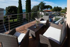 a patio with chairs and a table on a balcony at Apartments Villa Nona in Umag