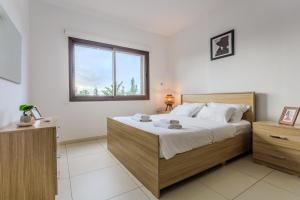 a bedroom with a large bed and a window at Resitour - Aphrodite Gardens in Paphos +54 photos