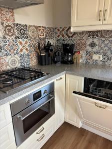 a kitchen with white cabinets and a stove top oven at Sint Anthonijshoek in Koudekerke +45 photos