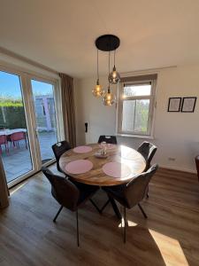 a dining room with a wooden table and chairs at Sint Anthonijshoek in Koudekerke