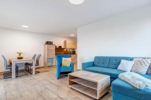 a living room with a blue couch and a table at Haus Achterwasserblick 1 in Loddin