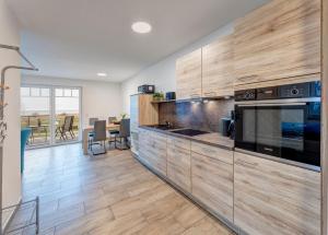 a kitchen with wooden cabinets and a large appliance at Haus Achterwasserblick 1 in Loddin +5 photos