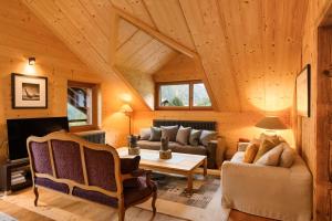a living room filled with furniture and a wooden ceiling at Chalet François in Champéry