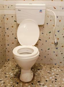 a white toilet in a bathroom with confederate at Roy Guest House in Kānki