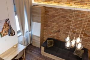 a living room with a couch and a brick wall at City Royal Studio in Székesfehérvár