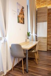 a wooden table and chairs in a room at City Royal Studio in Székesfehérvár