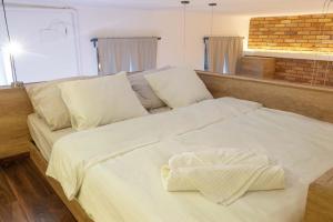 a large white bed with white sheets and pillows at City Royal Studio in Székesfehérvár +12 photos