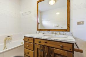 a bathroom with a sink and a mirror and a tub at Hostdomus - Chalet Claviere in Claviere +31 photos