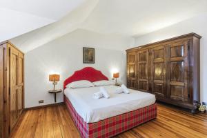 a bedroom with a large bed and wooden cabinets at Hostdomus - Chalet Claviere in Claviere