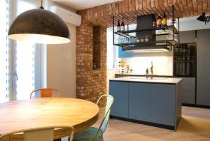 a kitchen with a wooden table and a dining room at El Surcinel – Alpine Design Home in Ballabio