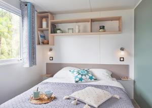 a small bedroom with a bed and a window at Camping le Laha in Lesperon
