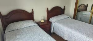 a bedroom with two twin beds and a mirror at Mar y Montaña in Laredo